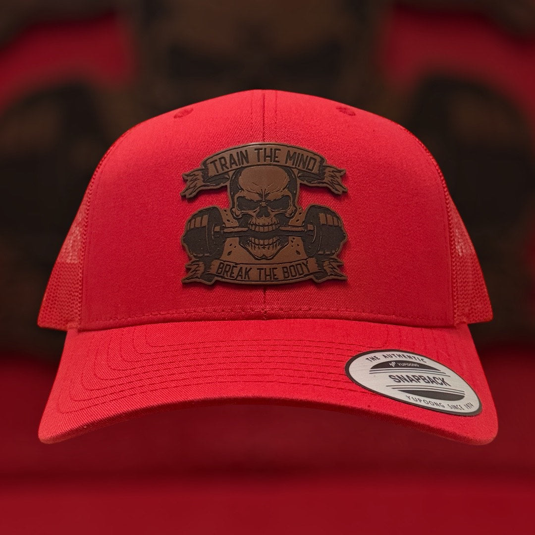 Red cap with a skull and barbell graphic and 'Train the Mind Break the Body' text on a red background.